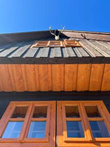 dwa okna na szczycie drewnianego budynku w obiekcie Traditional deer Cabin with Sauna w mieście Dolný Kubín