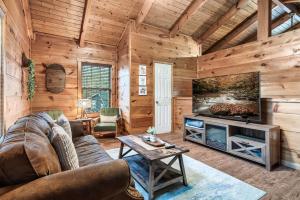 a living room with a couch and a tv at Mama Bear's Moonshine Ridge in Gatlinburg