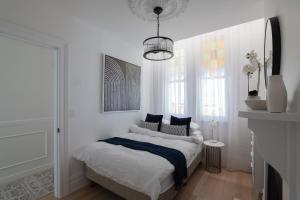 Dormitorio blanco con cama con almohadas azules en Unionelle a Luxe Newtown Terrance en Sídney