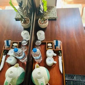 a wooden table with dishes and water glasses on it at Elegant Hamlets Home Stay in Chilaw