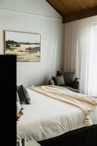 ein Schlafzimmer mit einem großen weißen Bett und einem Fenster in der Unterkunft Harry's On Moodemere in Rutherglen