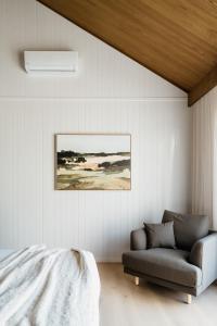 ein Schlafzimmer mit einem Sofa und einem Gemälde an der Wand in der Unterkunft Harry's On Moodemere in Rutherglen