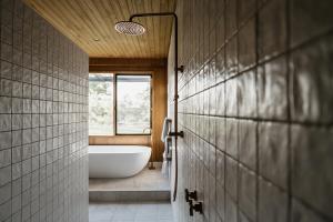 ein Bad mit einer weißen Badewanne und einem Fenster in der Unterkunft Harry's On Moodemere in Rutherglen