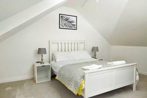 a white bedroom with a bed and two lamps at Pass the Keys Motherby 7 · Town House close to River front in Lincoln