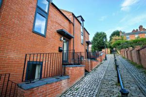 a brick building with a fence next to a street at Pass the Keys Motherby 7 · Town House close to River front in Lincoln