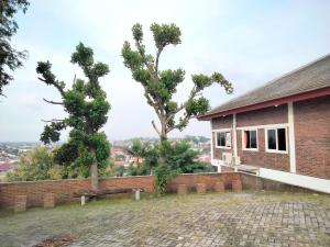 un edificio de ladrillo con un banco y árboles en el fondo en RedDoorz near Exit Tol Krapyak Semarang 3, en Kalibanteng-kidul