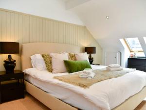 uma grande cama branca com almofadas verdes e brancas em Pass the Keys Classy house in Llanishen em Cardiff