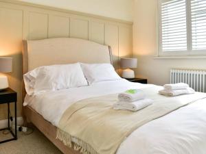 um quarto com uma grande cama branca com toalhas em Pass the Keys Classy house in Llanishen em Cardiff