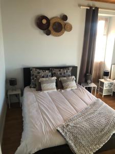ein Schlafzimmer mit einem großen Bett mit weißer Bettwäsche in der Unterkunft LES DOUCEURS DU LOGIS in La Garnache + 14 Fotos