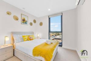 a bedroom with a bed and a large window at Vivid Condo 1B1B in Bankstown in Bankstown