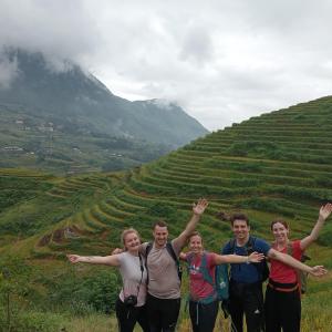 a group of people standing on a hill with their arms out at Miss Ann Homestay in Sa Pả