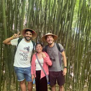 two men and a woman standing in a bamboo forest at Miss Ann Homestay in Sa Pả