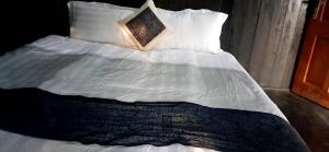 a bed with white sheets and pillows with a lamp on it at Miss Ann Homestay in Sa Pả