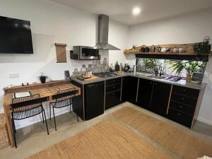 a kitchen with black cabinets and a counter top at Sunnyside Studio - Pet Friendly Luxury Escape in Port Macquarie