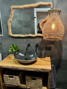 a bathroom sink on a wooden table with a mirror at Sunnyside Studio - Pet Friendly Luxury Escape in Port Macquarie