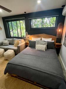 um quarto com uma cama grande e um sofá em Sunnyside Studio - Pet Friendly Luxury Escape em Port Macquarie