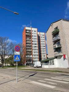 um sinal de rua em frente a um edifício alto em Panorama Suite Jelgava em Jelgava