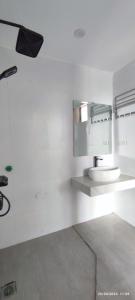 Baño blanco con lavabo y espejo en Xuân Lan Hotel, en Thương Xà (2)