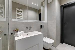 y baño con lavabo, aseo y espejo. en Lion Apartments - Sopot Fresh Wave Apartment with terrace and parking en Sopot
