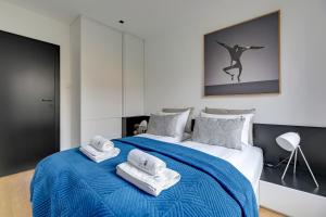 a bedroom with a bed with towels on it at Lion Apartments - Sopot Fresh Wave Apartment with terrace and parking in Sopot