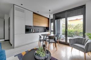 a kitchen and living room with a table and chairs at Lion Apartments - Sopot Fresh Wave Apartment with terrace and parking in Sopot
