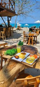 a plate of food on a wooden table on the beach at Buda House Beach in Playa Blanca