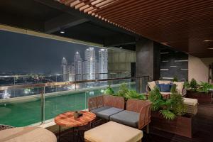 a balcony with a view of a city skyline at Whiz Luxe Hotel Spazio Surabaya in Surabaya