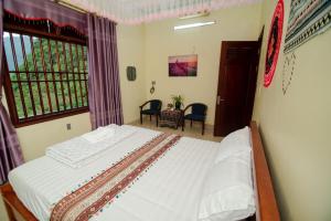 um quarto com uma cama num quarto com uma janela em Wind's House Ha Giang em Ha Giang