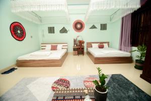 Zimmer mit 2 Betten und einem Tisch in der Unterkunft Wind's House Ha Giang in Ha Giang