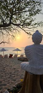 普拉亞布蘭卡的住宿－Buda House Beach，坐在海滩上观看日落的人
