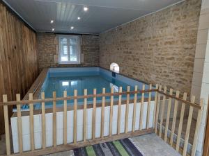 an indoor swimming pool with a brick wall at Gîte Forcey, 3 pièces, 4 personnes - FR-1-611-75 