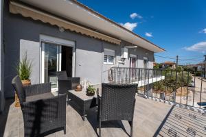 a patio with chairs and a table on a balcony at Elviras houses II in Agria