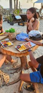 a group of women sitting at a picnic table with food at Buda House Beach in Playa Blanca