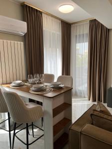 comedor con mesa, sillas y sofá en Apartament Andreea, en Mamaia Nord – Năvodari
