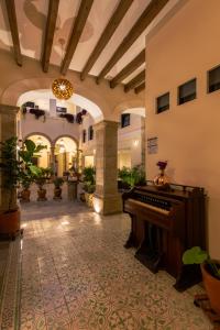 un vestíbulo con un piano en un edificio en Palpatio Hotel, en Guadalajara