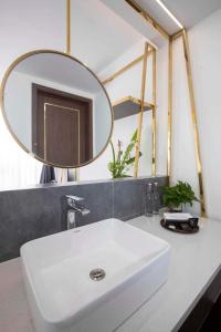 ein Badezimmer mit einem weißen Waschbecken und einem Spiegel in der Unterkunft Clover Home Đồng Hới in Dong Hoi