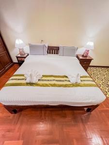 ein Schlafzimmer mit einem großen Bett mit Handtüchern darauf in der Unterkunft Hetai Boutique House in Chiang Mai