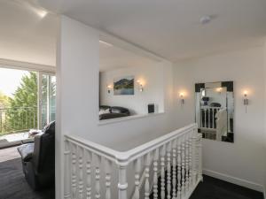 a white staircase in a house with a mirror at The Heights in Bowness-on-Windermere