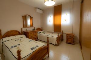 1 dormitorio con 2 camas y espejo en Casa Miragredos, a solo 5 min de Puy du Fou y Toledo, en Cobisa