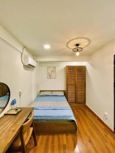 una camera da letto con un letto e un tavolo di legno di Larita Saigon ad Ho Chi Minh