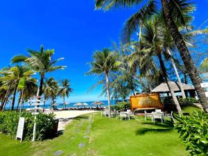 a resort with tables and chairs on the beach at Kosmos Phu Quoc Apart Hotel in Phu Quoc