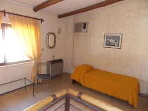 ein Schlafzimmer mit einem gelben Bett und einem Fenster in der Unterkunft Virginia Departamentos in San Rafael