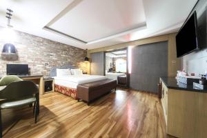 Q5 Hotel Busan Songdo في بوسان: غرفة نوم بسرير وجدار من الطوب