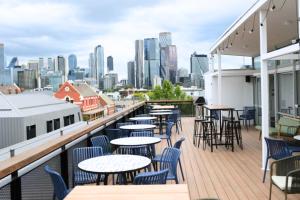 a balcony with tables and chairs and a city skyline at The Village North Melbourne in Melbourne