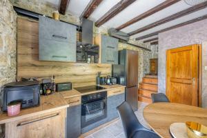 a kitchen with a stove and a table with chairs at Casa La Vida - Happy Rentals in Livade