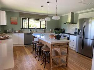 a kitchen with a large island with bar stools at Willow Cottage Retreat in Brightwater
