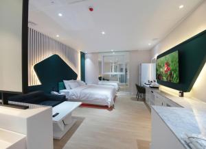 a hotel room with a bed and a tv at WJ Hotel Pool House in Wonju
