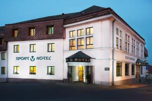 a large white building with a sign for a hotel at Sport-V-Hotel in Hrotovice