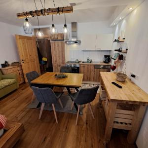 a kitchen with a wooden table and chairs at Appartement mit Hallenbad in Sankt Martin bei Lofer
