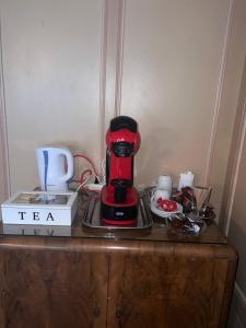 a red coffee maker sitting on top of a wooden cabinet at Hotel krone habitación doble in Zäziwil